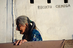 Ignacia Quimi camina frente a su casa tras haber tendido la ropa, en la comunidad de La Ciénega, provincia de Santa Elena. Foto: Santiago Arcos